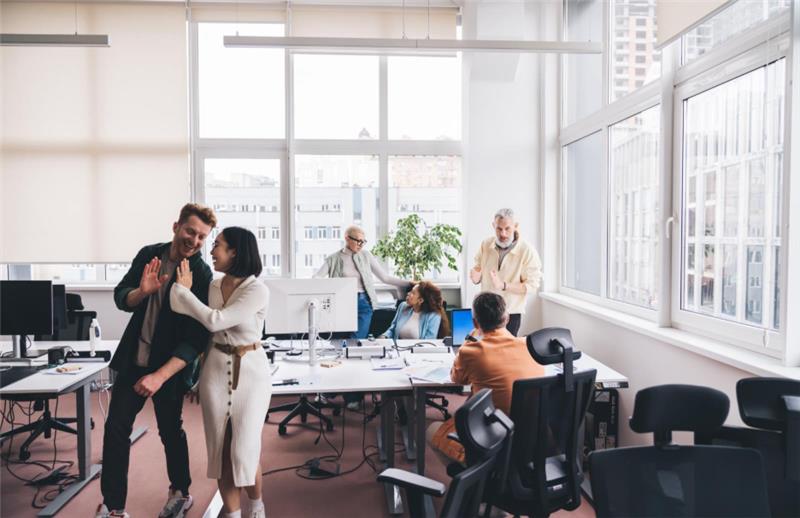 office space with smiling workers talking to each other
